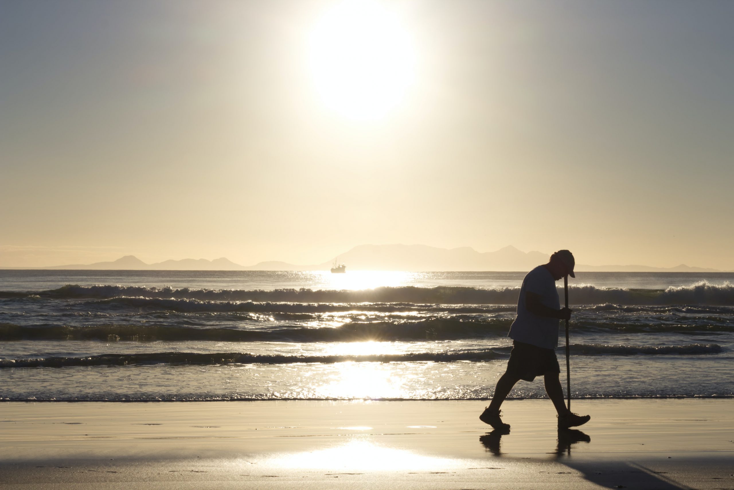 Picture of an older male walking on the beach and engaging in low impact exercise