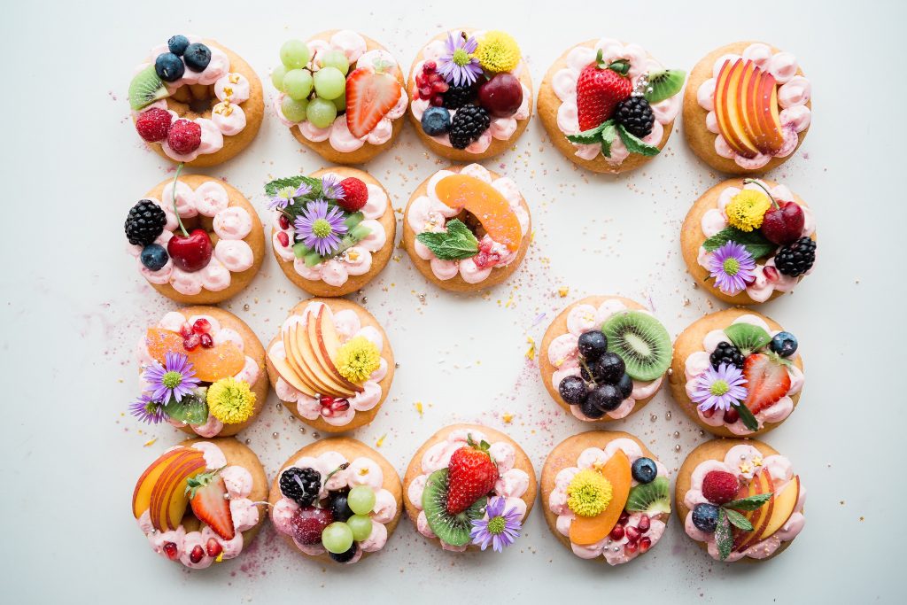 Picture of intricate pastries with flowers and fruit decorated on these boutique baked goods from a gluten free bakery in Melbourne