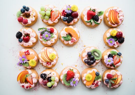 Picture of intricate pastries with flowers and fruit decorated on these boutique baked goods from a gluten free bakery in Melbourne