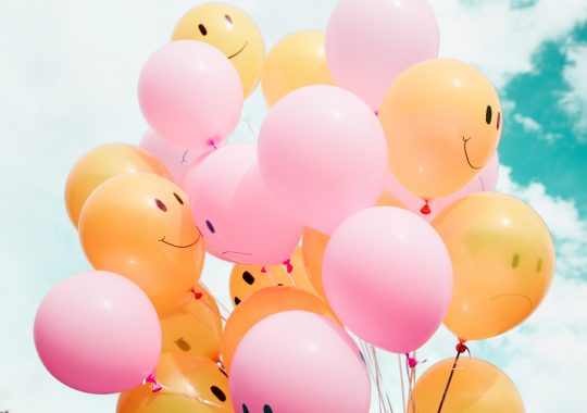 Picture of smiling and frowning balloons in the air, celebrating the many Melbourne school holidays activities happening around the city