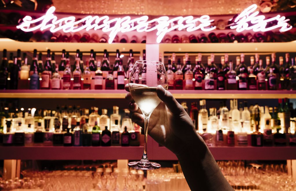 Picture of a raised champagne glass at Pinchy's restaurant in Melbourne, celebrating cultural events in Melbourne like Bastille Day