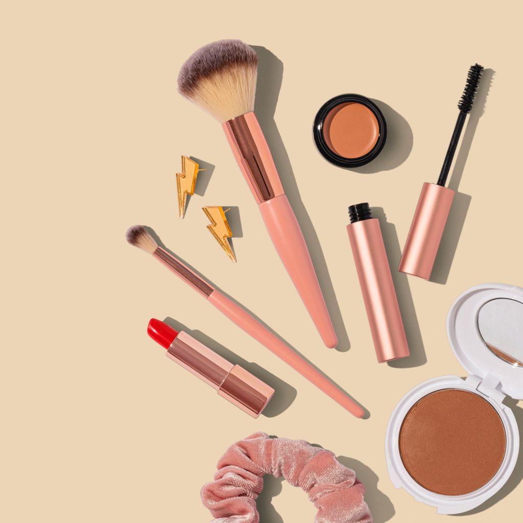 Flatlay picture of beauty products scattered on a desk, depicting the things discussed on the best beauty podcasts in Australia