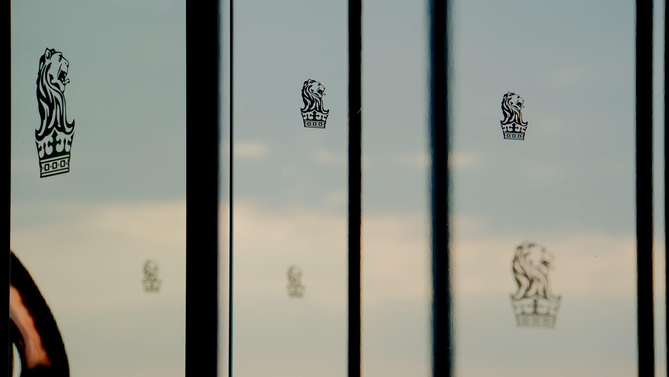 Picture of a window with clouds in the background and a Ritz Carlton Melbourne decal sticker in the foreground