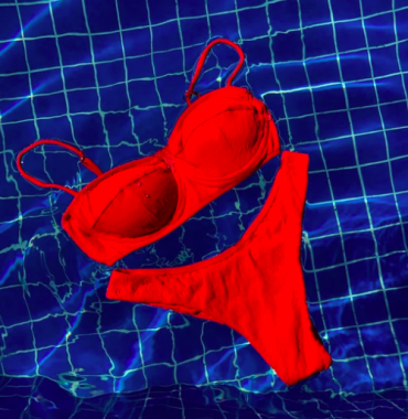 Brazil Born bikini in an electric orange colour floating on the surface of a pool