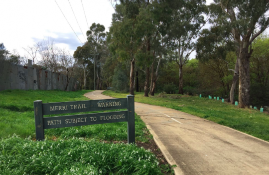 Merri Creek walking trail in Melbourne, with sign warning flash flooding