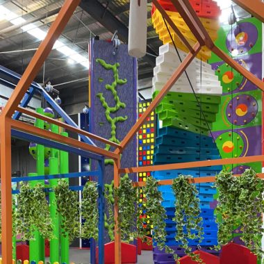 Picture of the climbing walls at Go Climb Coburg, each of them bright in colour and in different shapes