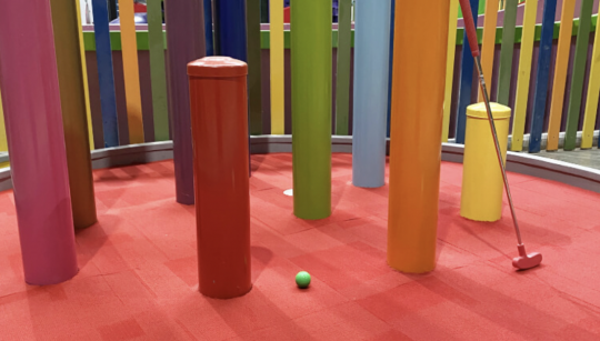 Picture of the mini golf putt putt course in Coburg, with bright beams creating an obstacle course