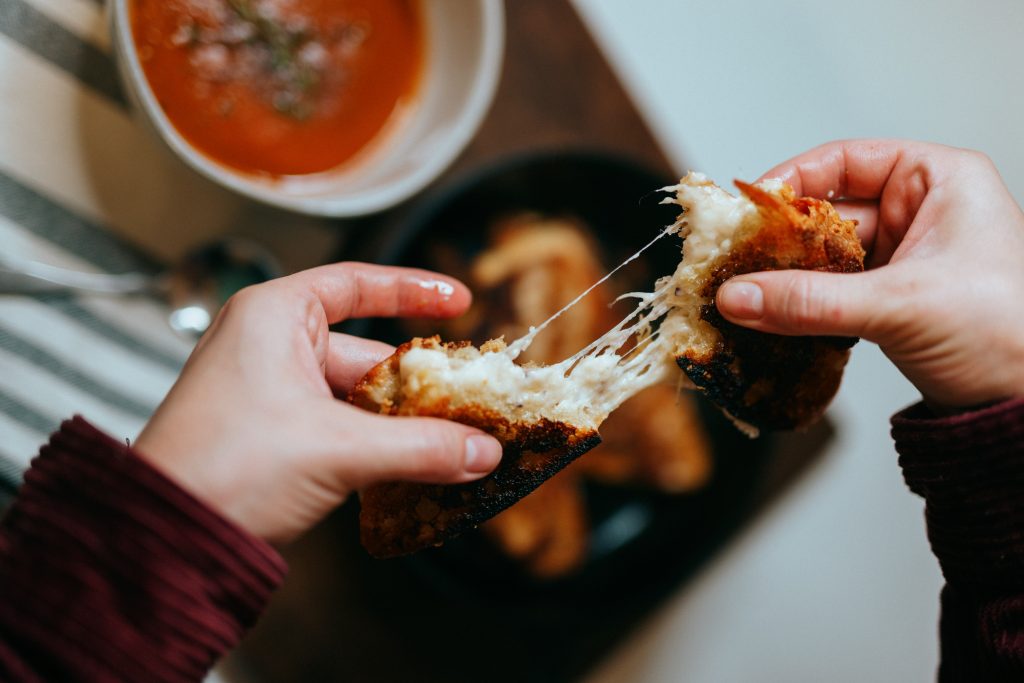 Picture of a child pulling apart a grilled cheese toasted sandwich at one of the kid friendly Melbourne restaurants