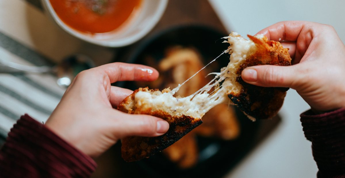 Picture of a child pulling apart a grilled cheese toasted sandwich at one of the kid friendly Melbourne restaurants