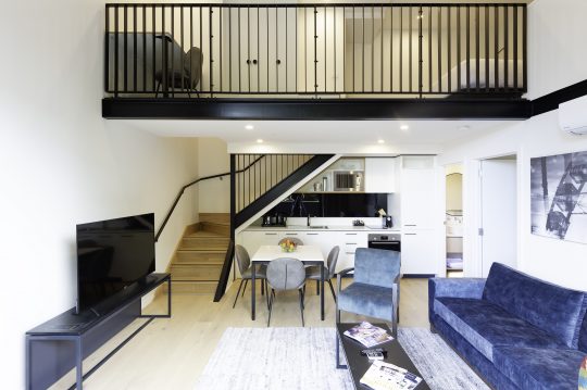 Picture of the two bedroom apartment at R Hotel Geelong, which is 2 floors and shows a kitchen and living space with a staircase