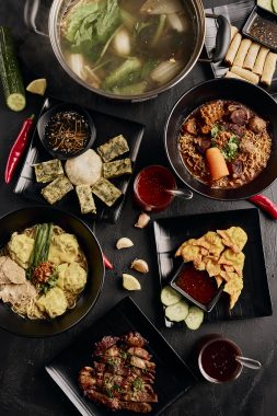 Picture of a flat-lay of menu items that feature on the Cambodia's Kitchen menu, featuring spring rolls, wonton soup, stir-fry and various asian-inspired dishes