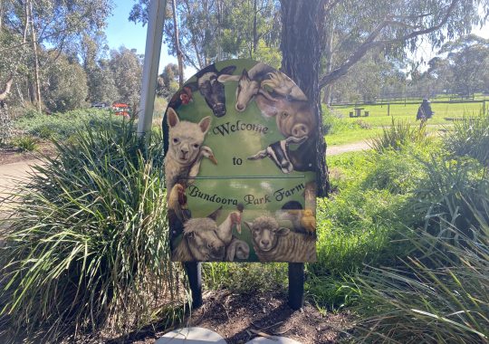 Picture of a sign that says "Welcome to Bundoora Park Farm" with animals all around the edges of the sign