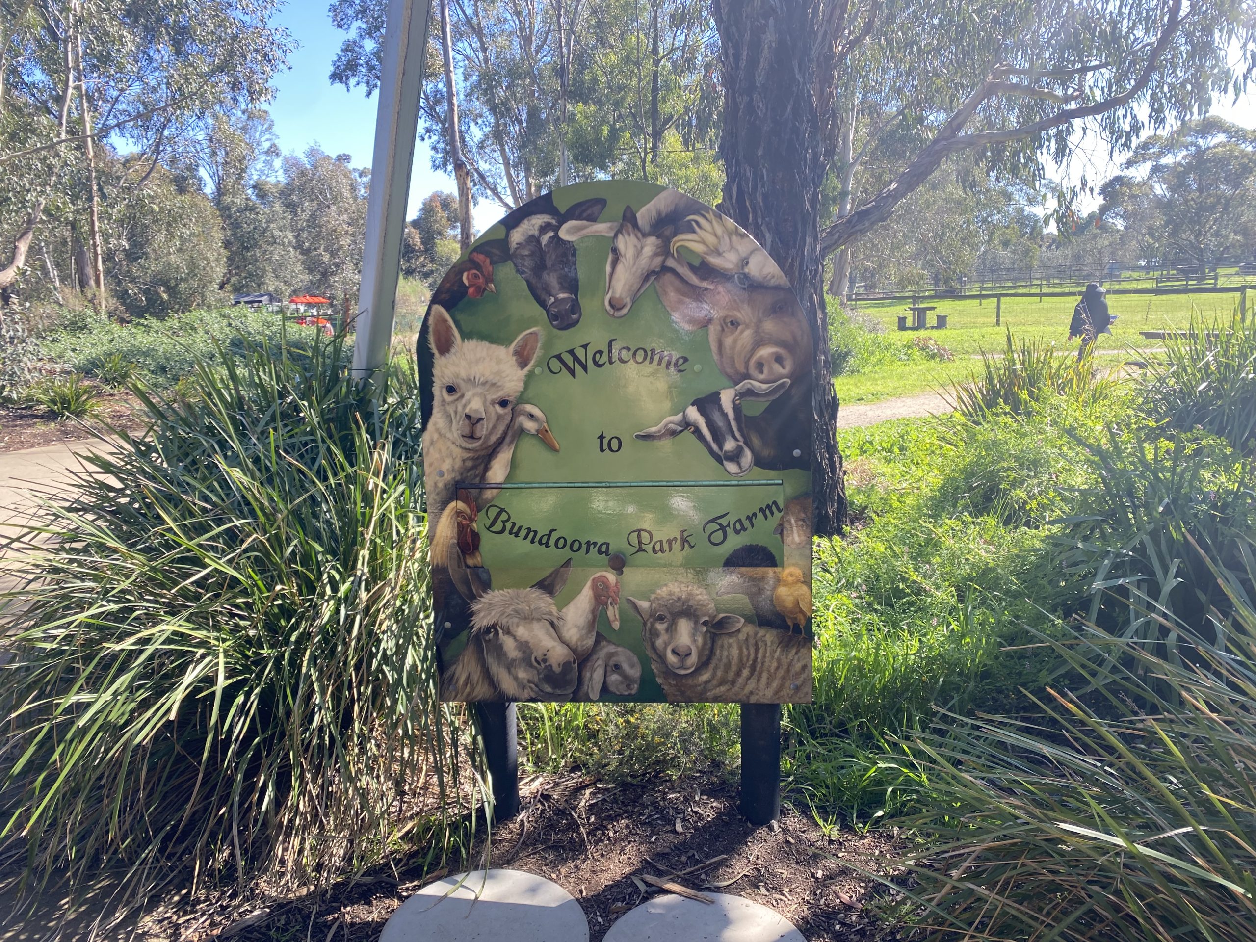 Picture of a sign that says "Welcome to Bundoora Park Farm" with animals all around the edges of the sign