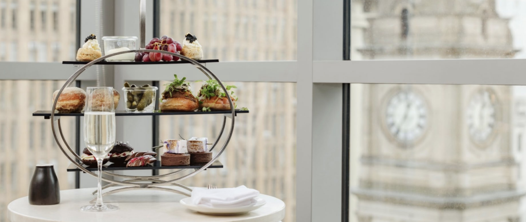 Picture of a high tea stand with a glass of champagne in front of a window at The Westin Melbourne