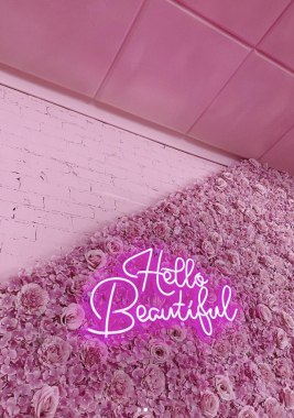 Picture of the Feekah cafe Melbourne decor, with a rose-lined wall and pink brickwork and a sign that reads 'Hello Beautiful'