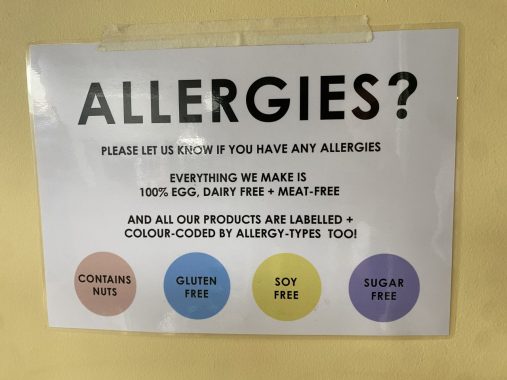 Picture of the allergy key at Mister Nice Guy's Bakeshop, with the sign showing different colours for 'contains nuts', 'gluten free', 'soy free' and 'sugar free'