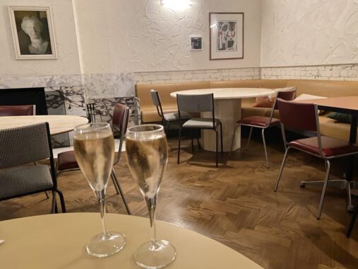 Picture of two rose sparkling glasses on a table with the Railway Hotel Brunswick decor in the background