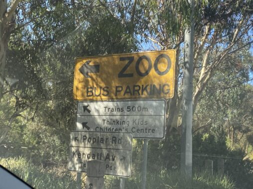 Picture of a Melbourne Zoo parking sign which shows were to get the train, tram and entrance to the street