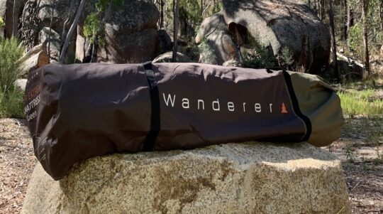 Picture of a Wanderer self inflating matress in a carry bag sitting on a rock