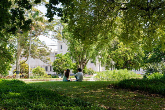 Picture of the Carlton Gardens Melbourne with people looking at Exhibition Buildings