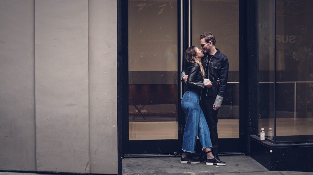 Picture of a man and a woman kissing in front of a building for Humpday Dating launch event