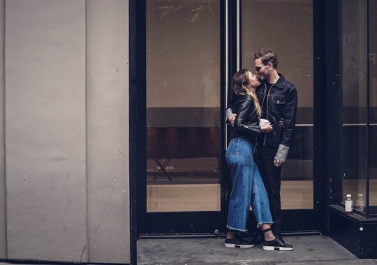 Picture of a man and a woman kissing in front of a building for Humpday Dating launch event