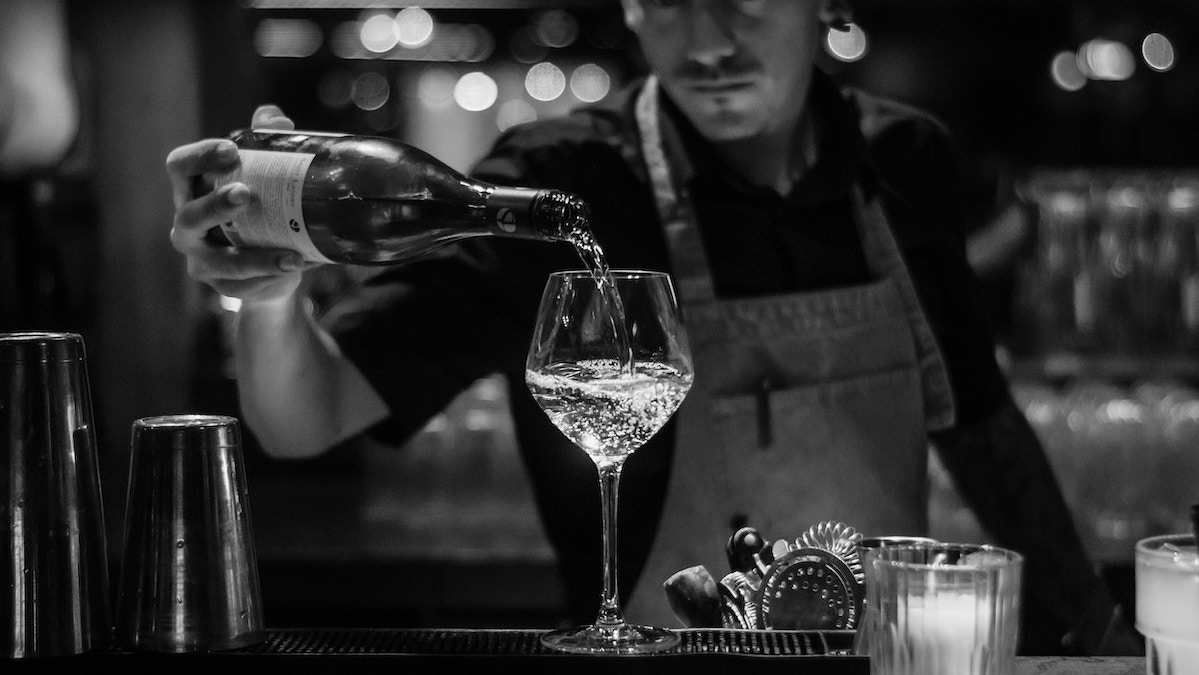 Picture of a man pouring a glass of wine at one of the best wine in Melbourne