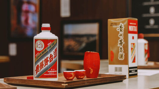 Kweichow Moutai 500ml bottle with traditional cups and branded box on a table