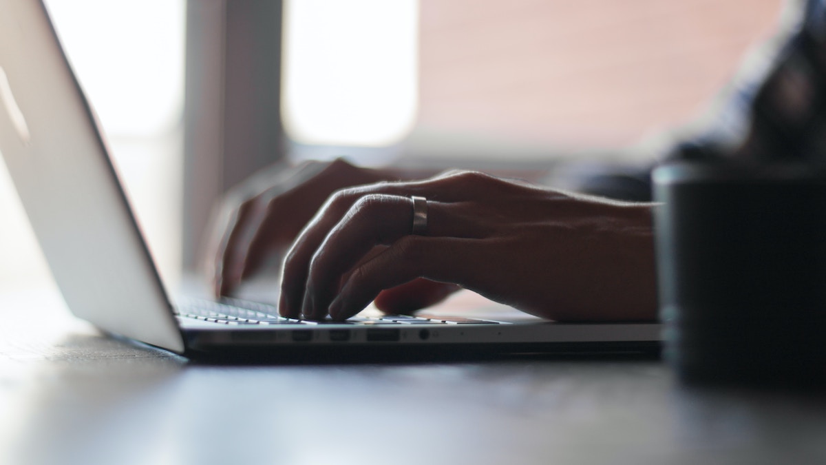 Picture of someone typing on a laptop engaging in online safety protocol