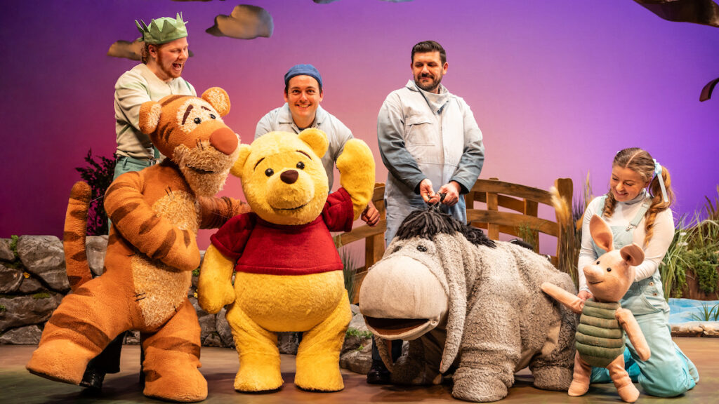 Winnie the Pooh, Tigger, Eeyore and Piglet are standing as life size puppets