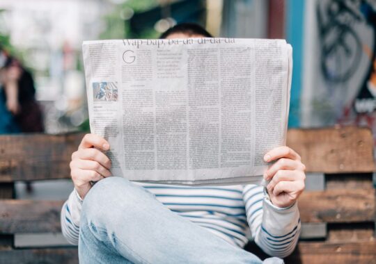 Picture of person reading about defamation case in the newspaper