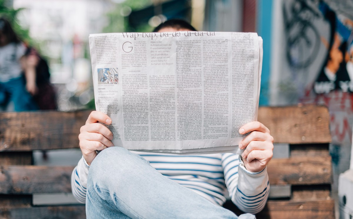 Picture of person reading about defamation case in the newspaper