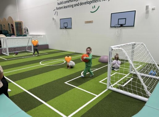 Children playing soccer on an indoor soccer pitch at Eden Play Mill Park play centre