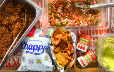 Flat lay picture of a bag of Chappy's Chips with Mingle Seasoning and toppings to create loaded chips